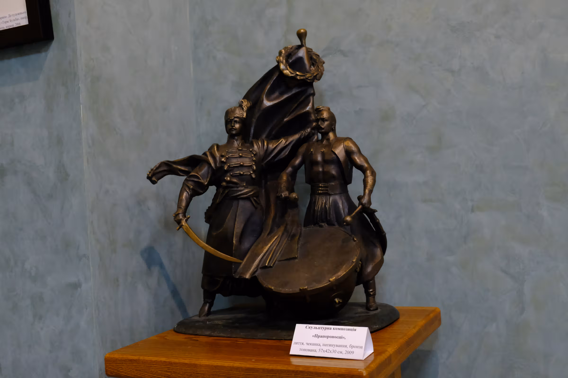 Скульптурна композиція «ПРАПОРОНОСЦІ».  Анатолій Васильйович Кущ,  2009 рік. Матеріал скульптурної композиції: бронза тонована. Техніка виконання: лиття, прочеканка, патинування. Розмір скульптурної композиції: 57х42х30 см.